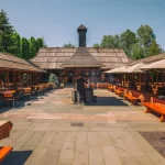 Дворик с деревянными столами и лавками возле санатория «Карпаты» в Трускавце