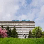 Санаторій Кристал у Трускавці серед зеленої трави і квітучих дерев