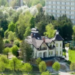 Вілла серед зелені на тлі багатоповерхового будинку у Трускавці