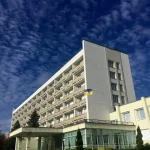 Фасад санаторію «Шахтар» у Трускавці на тлі неба та зеленої території
