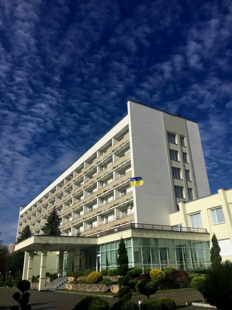 Фасад санаторію «Шахтар» у Трускавці на тлі неба та зеленої території