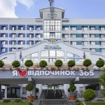 Фасад готелю «Трускавець 365» з декоративними рослинами та сходами у Трускавці