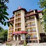 Фасад санаторію Арніка у Трускавці з балконами та входом серед зеленої території
