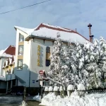 Санаторій «Арніка» у Трускавці взимку, будівля та засніжені дерева