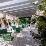 Тераса вілли «Хижина SPA» з білим настилом і зеленими кріслами у Трускавці