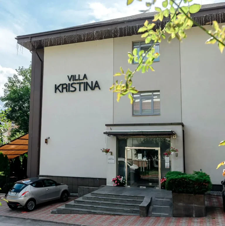 Фасад вілли Христина у Трускавці з головним входом і квітами біля сходів