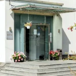 Вхід до вілли Христина у Трускавці зі скляними дверима та квітами