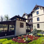 Вілла «Моцарт» у Трускавці з доглянутим квітником та прогулянковою доріжкою біля фасаду