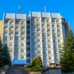 Санаторий в Трускавце среди зеленых елей на фоне голубого неба