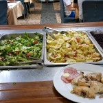 Салат-бар и тарелка с курицей и колбасой в ресторане курортного комплекса в Трускавце