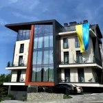 Готель Раймонд у Трускавці з великими скляними вікнами і національним прапором УКРАЇНИ