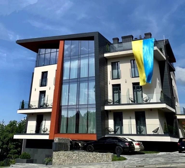 Готель Раймонд у Трускавці з великими скляними вікнами і національним прапором УКРАЇНИ