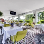 Тераса з обідніми столами і квітами в курорті Rixos-Prykarpattya у Трускавці