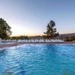 Відкритий басейн курортного комплексу Rixos-Prykarpattya у Трускавці з шезлонгами та гіркою