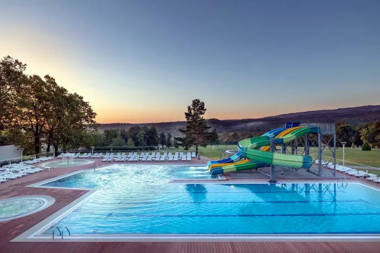 Відкритий басейн з гірками курортного комплексу Rixos-Prykarpattya у Трускавці на заході сонця