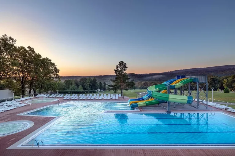 Відкритий басейн з гірками та шезлонгами у курортному комплексі Rixos-Prykarpattya Трускавець